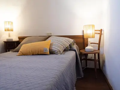 a bedroom with a bed with two lamps on two tables at CA L'ESTADANT in Abrera