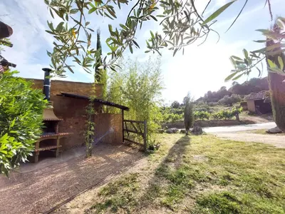 a farmhouse with a gate in a field at CA L'ESTADANT in Abrera
