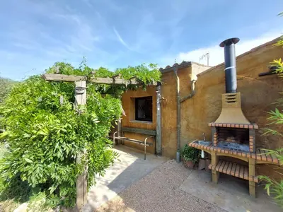a building with a stove and a bench in front of it at CA L'ESTADANT in Abrera