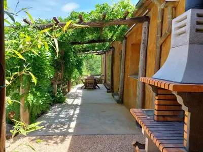 a walkway leading to a building with a bench at CA L'ESTADANT in Abrera