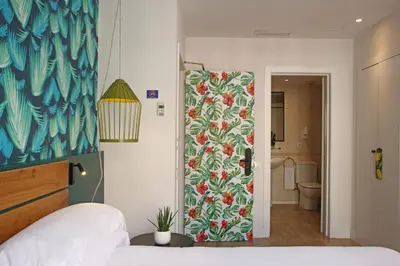 a bedroom with a bed and a painting on the wall at Chic & Basic Lemon Boutique Hotel in Barcelona