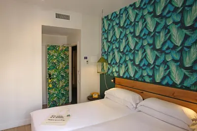 a bedroom with a bed with a blue and green wall at Chic & Basic Lemon Boutique Hotel in Barcelona