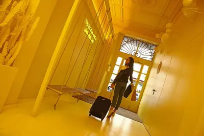 a woman standing in a hallway with a suitcase at Chic & Basic Lemon Boutique Hotel in Barcelona
