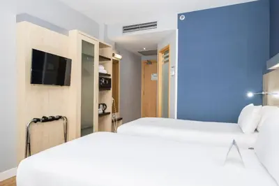 a hotel room with two beds and a tv at Holiday Inn Express Barcelona City 22@ by IHG in Barcelona