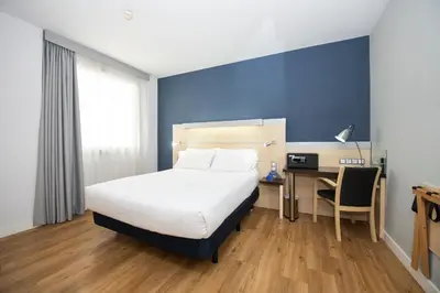 a bedroom with a bed and a desk with a chair at Holiday Inn Express Barcelona City 22@ by IHG in Barcelona
