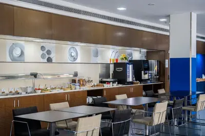 a restaurant with tables and chairs and a kitchen at Holiday Inn Express Barcelona City 22@ by IHG in Barcelona