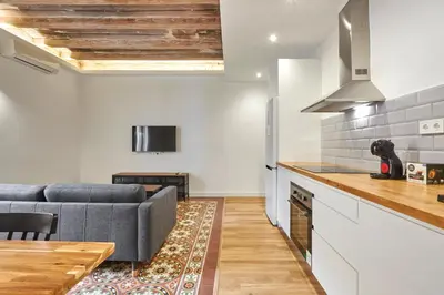 a kitchen and living room with a couch and a table at Comfortable apartment next to Apolo theater in Barcelona