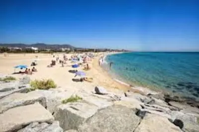 a group of people on a beach with the ocean at Apartamento a 5' de la playa in Premiá de Mar