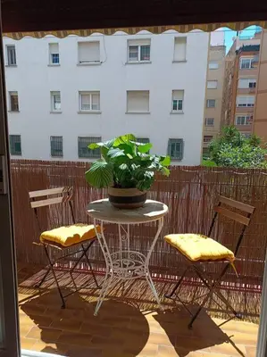 a patio with a table and two chairs and a plant at Apartamento a 5' de la playa in Premiá de Mar