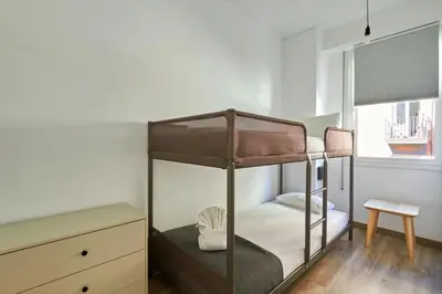 a bedroom with a bunk bed with a chair and a drawer at Ol Cute apartment in quiet Olivera st in Barcelona