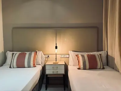 a bedroom with two beds and a night stand at Sweet BCN Borrell in Barcelona