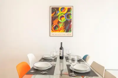 a dining room table with a bottle of wine and a painting at Centric apartment Gràcia in Barcelona