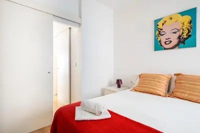 a bedroom with a white bed with a red blanket at Centric apartment Gràcia in Barcelona