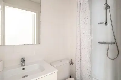 a white bathroom with a sink and a shower at Centric apartment Gràcia in Barcelona