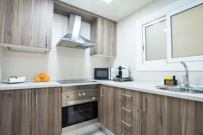 a kitchen with wooden cabinets and a sink and a microwave at Home365 · Barberá del Vallés · Barcelona in Barbera del Valles