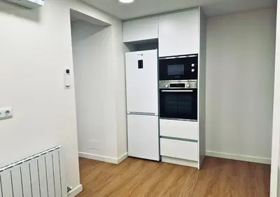 a white kitchen with a refrigerator and a microwave at Sweet BCN Laforja in Barcelona