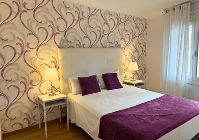 a bedroom with a bed and two tables with lamps at Sweet BCN Laforja in Barcelona