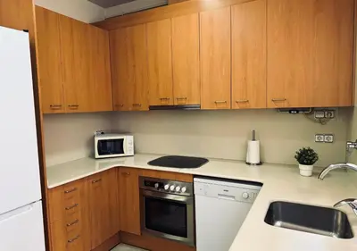 a kitchen with wooden cabinets and a microwave at Sweet BCN Laforja in Barcelona