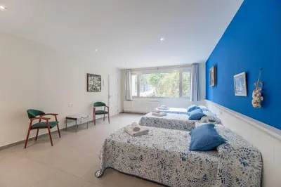 a bedroom with two beds and a blue wall at Casa Majestic in Cunit