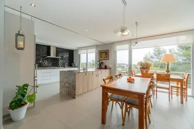 a kitchen and dining room with a wooden table and chairs at Casa Majestic in Cunit