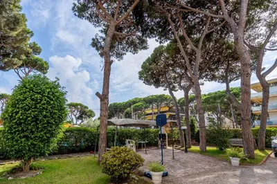 a park with trees and a table and an umbrella at Beachside Bliss in Castelldefels