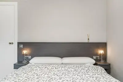a bed with two pillows on top of it at Beachside Bliss in Castelldefels
