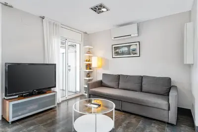 a living room with a couch and a tv at Beachside Bliss in Castelldefels