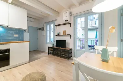 a kitchen and dining room with white cabinets and a table at Amazing flat in Barceloneta with private terrace 2-2 in Barcelona