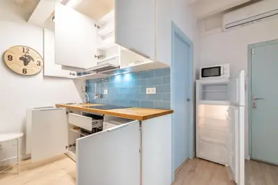 a kitchen with white cabinets and a blue tiled wall at Amazing flat in Barceloneta with private terrace 2-2 in Barcelona