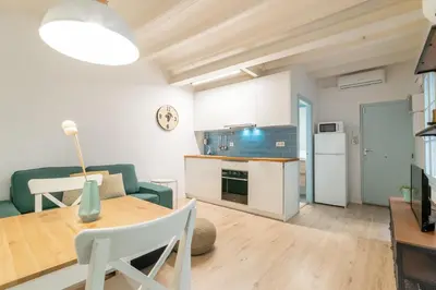 a living room with a table and a kitchen at Amazing flat in Barceloneta with private terrace 2-2 in Barcelona