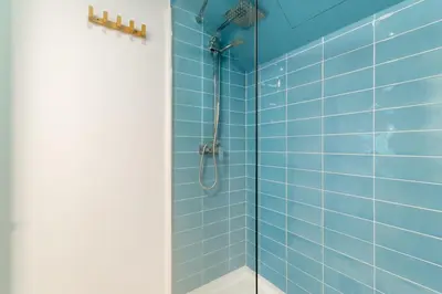 a bathroom with a shower with blue tiles at Amazing flat in Barceloneta with private terrace 2-2 in Barcelona