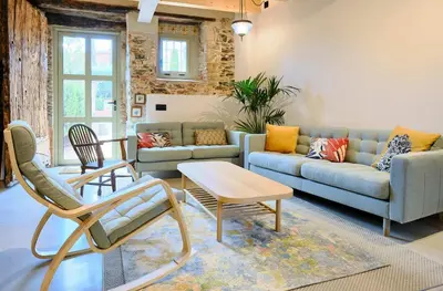 a living room with a couch and a table and chairs at Hotel Molí Cardedeu in Cardedeu
