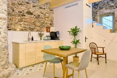 a kitchen with a wooden table and chairs at Hotel Molí Cardedeu in Cardedeu