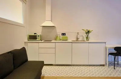 a kitchen with white cabinets and a microwave at Hotel Molí Cardedeu in Cardedeu