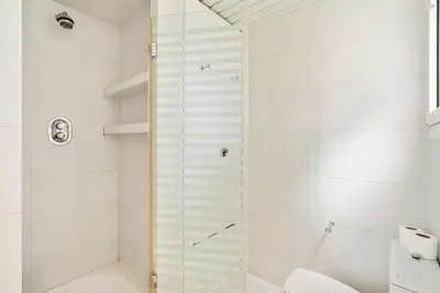 a white bathroom with a shower and a toilet at Casa Mediterránea con jardín y piscina privada in Masnou