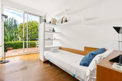 a white room with a bed and a large window at Casa Mediterránea con jardín y piscina privada in Masnou