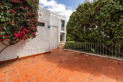 a brick patio with two large trees and flowers at Casa Mediterránea con jardín y piscina privada in Masnou