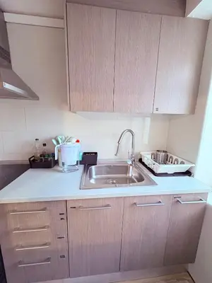 a kitchen with a sink and wooden cabinets at Stunning flat for 6 people 3 blocks from the beach plus welcome breakfast in Barcelona