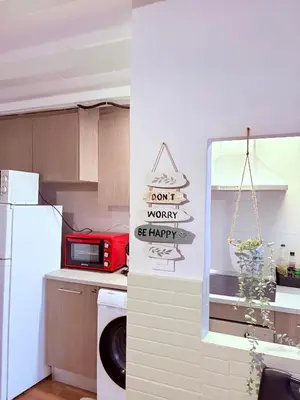 a kitchen with a refrigerator and a sign that reads dont worry be happy at Stunning flat for 6 people 3 blocks from the beach plus welcome breakfast in Barcelona