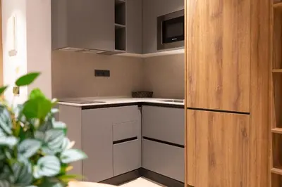 a small kitchen with white cabinets and a refrigerator at Monturiol Apartaments in Barcelona