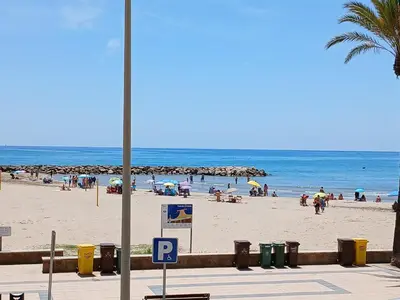 a beach with people on the sand and the ocean at Primera linea in Cunit