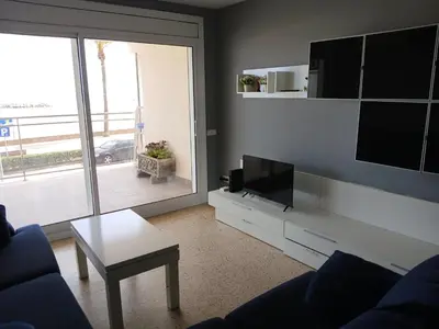 a living room with a couch and a tv and a table at Primera linea in Cunit