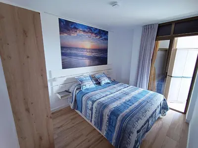 a bedroom with a bed with a painting on the wall at Apartamento nuevo en Calella totalmente reformado con Parking privado in Calella