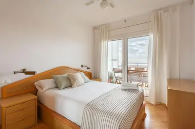 a bedroom with a bed and a large window at Sunset oceanfront in Castelldefels