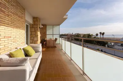 a balcony with a couch and a view of the ocean at Sunset oceanfront in Castelldefels