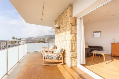 a living room with a stone wall at Sunset oceanfront in Castelldefels