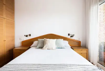 a bedroom with a large bed with white sheets at Sunset oceanfront in Castelldefels