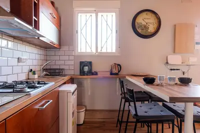a kitchen with a table and a clock on the wall at Atico con Terraza en Fira Barcelona - Negocios y Turismo en Sants - Montjuic in Barcelona