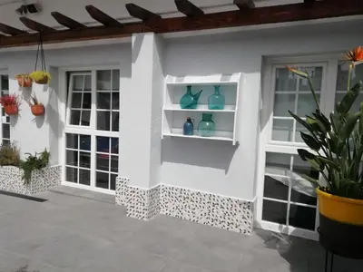 a house with white walls and windows with vases on shelves at Hotel Mediterrani Express in Calella