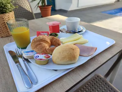 a plate of food with bread and cheese on a table at Hotel Mediterrani Express in Calella